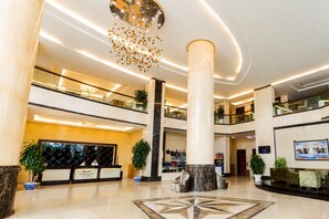A multi-level hotel lobby with a reception desk, a large chandelier, and a marble floor. - Căn hộ 3PN Rộng Rãi 88m2 - Mường Thanh Ba Làng | Gần Biển Hòn Chồng (Bắc Nha Trang)