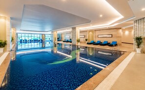 An indoor swimming pool with lounge chairs and a view of the outdoors. - Căn hộ 3PN Rộng Rãi 88m2 - Mường Thanh Ba Làng | Gần Biển Hòn Chồng (Bắc Nha Trang)