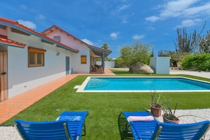 A swimming pool with a patio area, a covered seating area, and a well-maintained lawn. - Mermaid's Treasure - 3BR Villa (Santa Cruz)