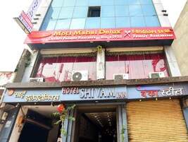 A hotel with a sign for 'Hotel Shiva Inn' and a restaurant named 'Moti Mahal Deluxe'.