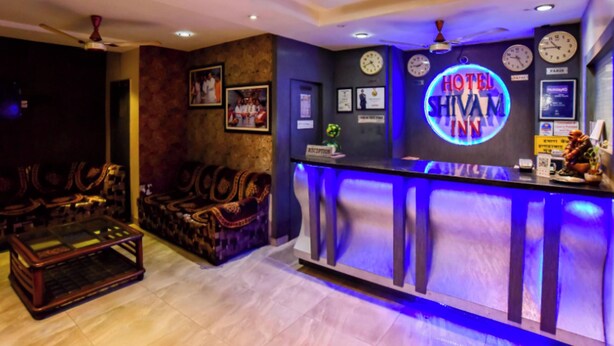 A hotel reception area with a counter, seating, and ceiling fans. - Muzzafarpur Inn Shivam on Motijheel Rd. (Muzaffarpur)