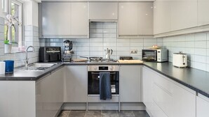 Una cocina moderna con electrodomésticos de acero inoxidable, horno integrado y ventana con vistas.