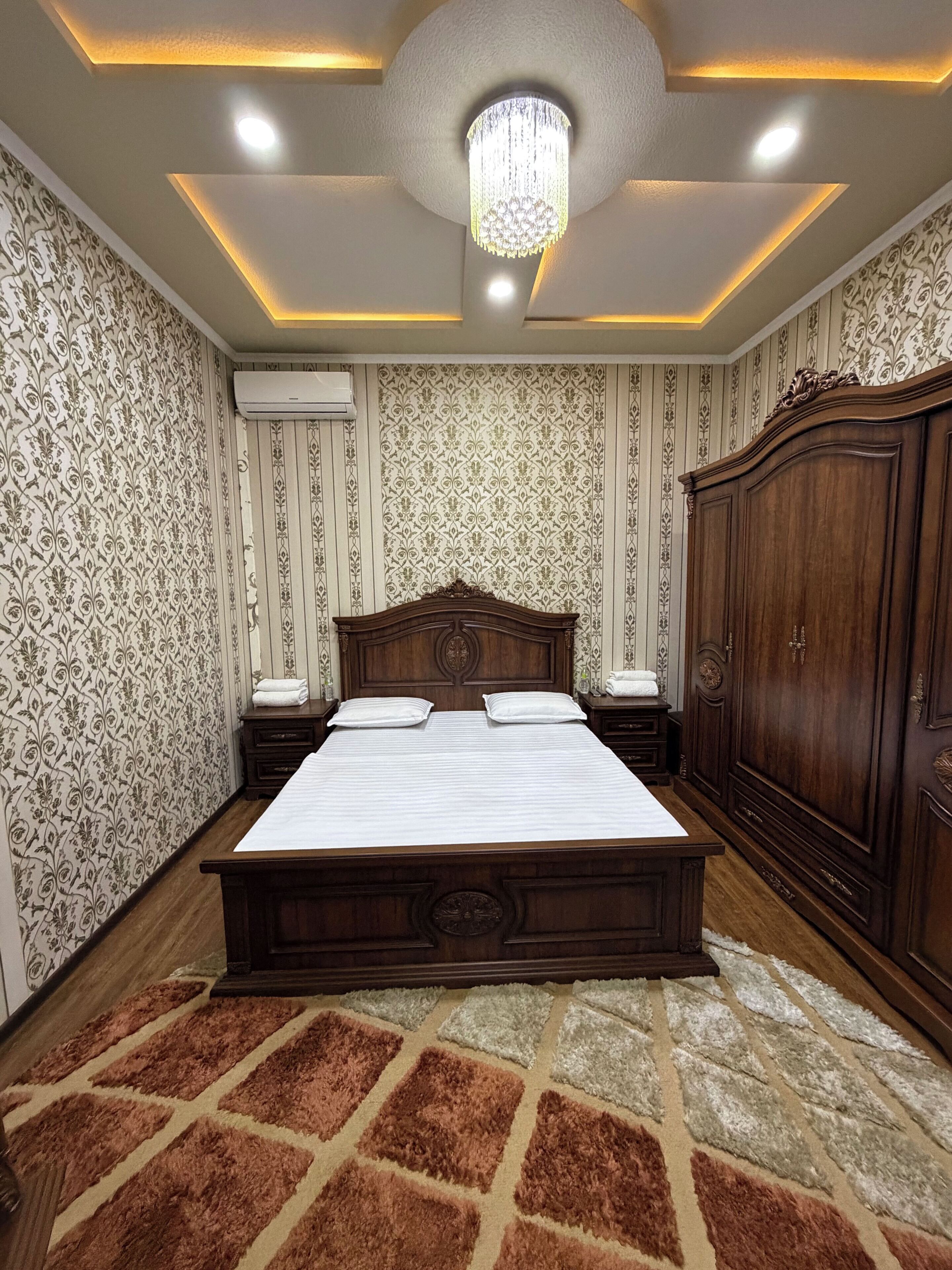 Un dormitorio con una cama grande, un armario y una araña.