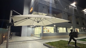 Um edifício com área de estar coberta ao ar livre, uma estátua e um pavimento estampado.