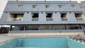 Um edifício moderno com piscina na frente.