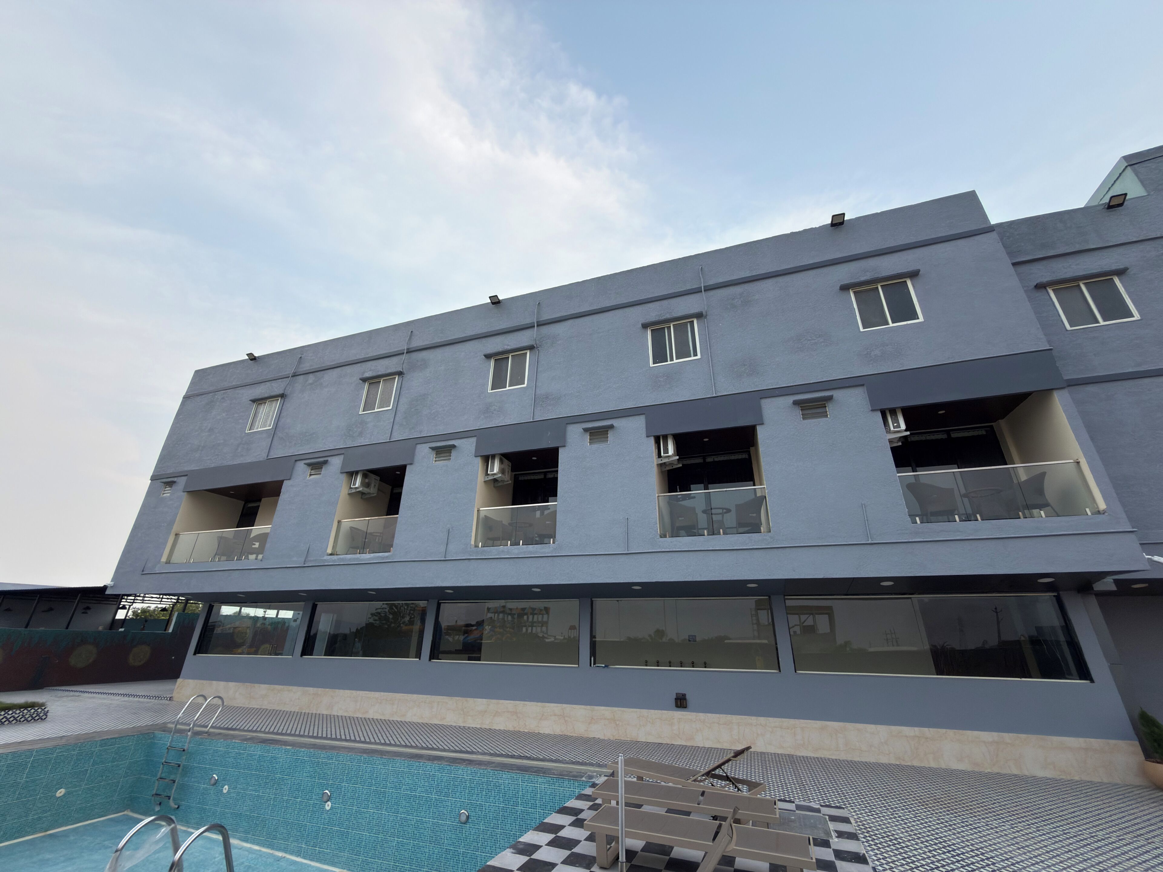 A modern building with multiple balconies and a swimming pool area.
