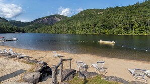 Uma praia à beira do lago com espreguiçadeiras e um píer.