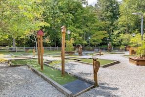Un jardin agrémenté de nichoirs en bois, d’une clôture en bois et de différentes espèces d’arbres.