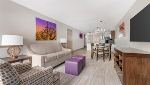 Un saló modern amb un sofà, una taula de centre i una zona de menjador amb cadires i taula.