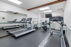 Ein Fitnessraum mit Laufbändern, einem Ergometer und einem Rudergerät.