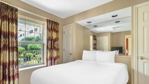 Ein Hotelzimmer mit einem großen Bett, einem Fenster mit Vorhängen, einer Tür und einer Decke mit Einbaustrahlern.
