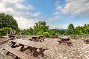 Ein Außenbereich mit Terrassentischen und Grillmöglichkeiten.