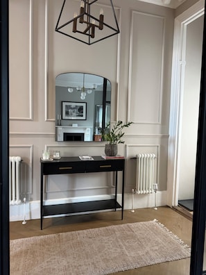 A room with a black console table, a mirror, a fireplace, and a radiator. - Spacious 3-bedroom house in a wonderful London neighborhood (London)