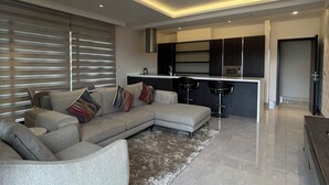 Ein modernes Wohnzimmer mit einem Ecksofa, einem Couchtisch und einem Teppich.
