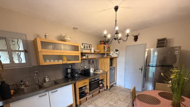 Eine Küche mit Kühlschrank, Herd, Spüle und Holzschränken.