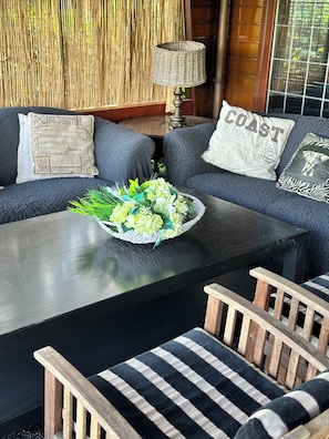 A modern living room with a sofa set, a coffee table, and a wicker lamp.