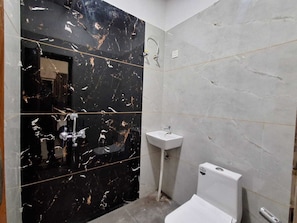 Een douche, handdoeken, zeep, toiletpapier