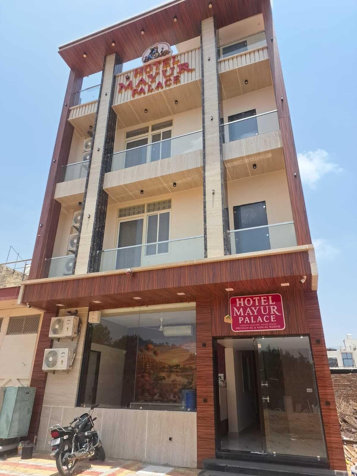 Un hotel de varios pisos con un letrero que dice 'Hotel Mayur Palace'.