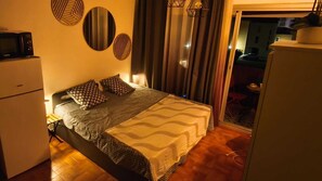 Ein Hotelzimmer mit Bett, Kühlschrank, Mikrowelle und Blick nach außen.