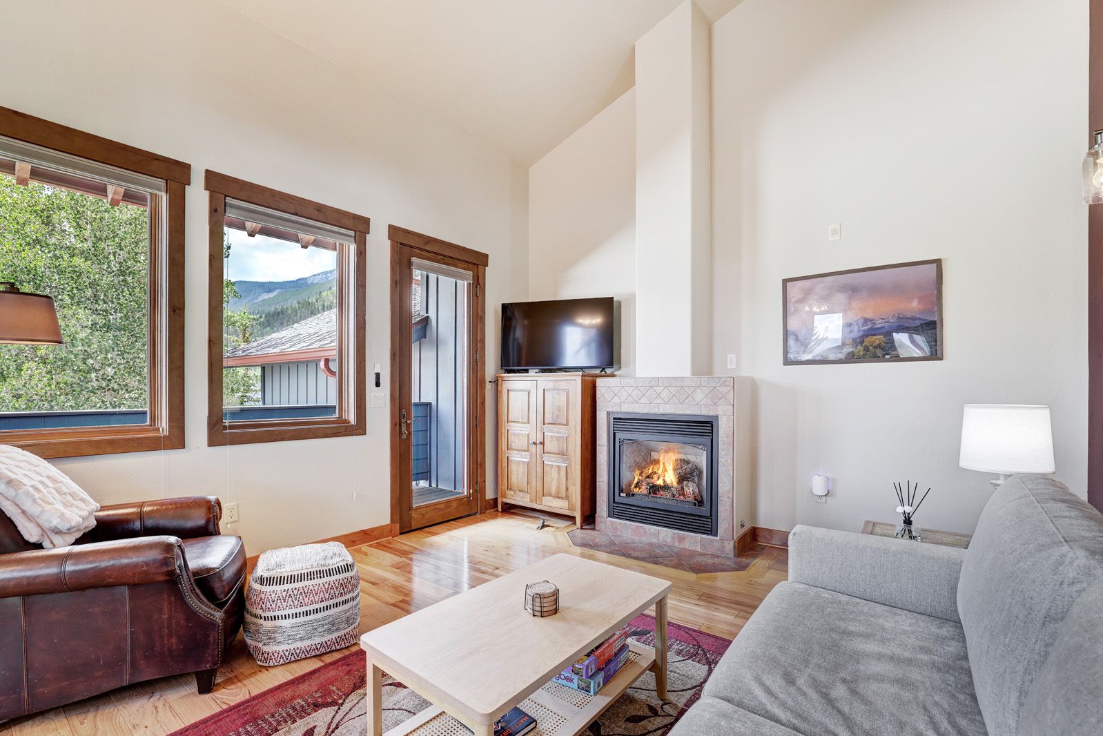 Ein Wohnzimmer mit Kamin, einer Couch, einem Couchtisch und einem Fernseher.