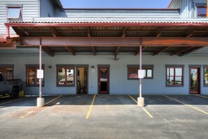A building with a covered entrance, multiple windows, and a parking area with marked spaces. - RARE One Bedroom Condo w/Private Hot Tub on Main Street (Frisco)