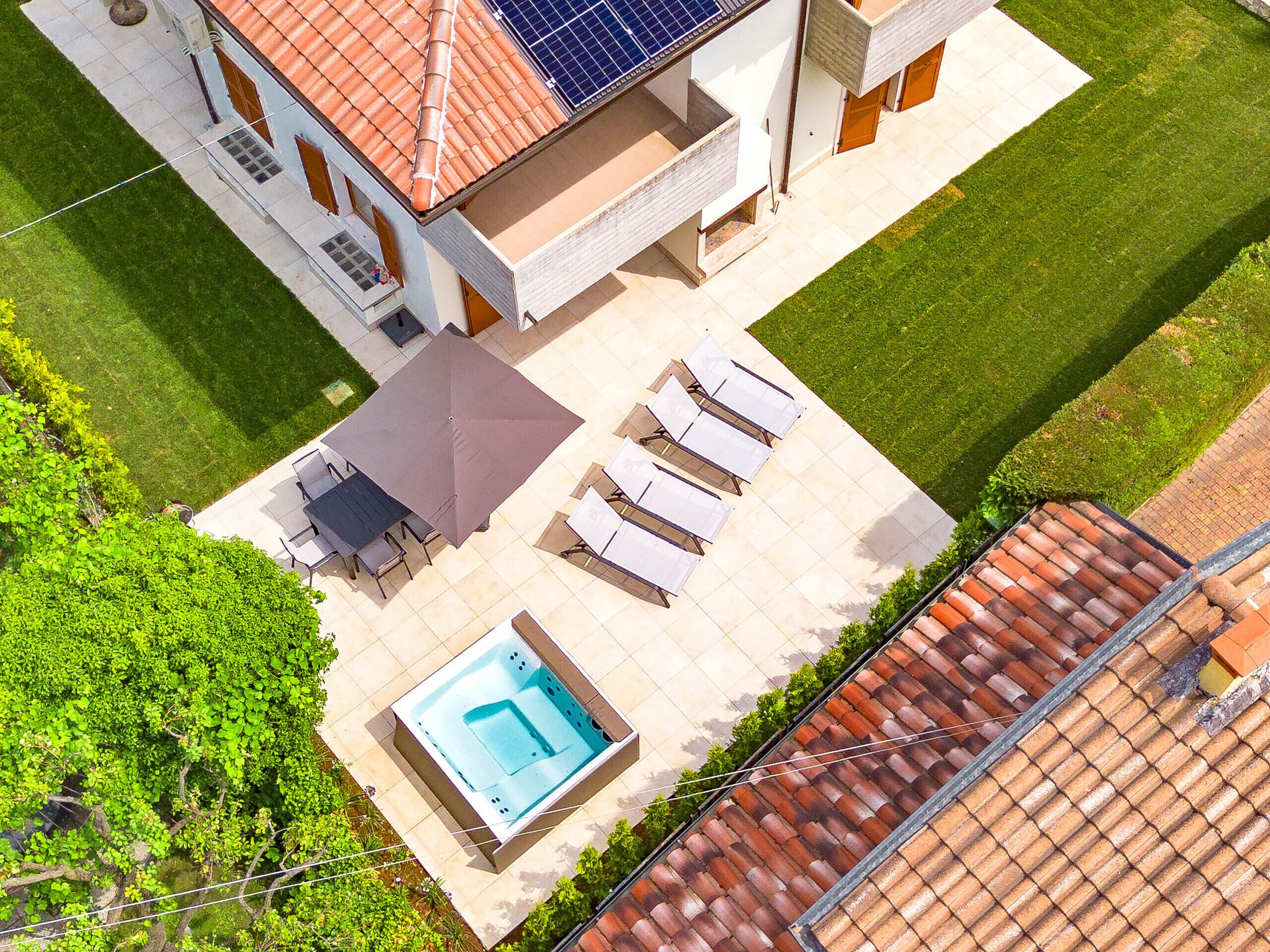 A rooftop pool area with lounge chairs and a hot tub.