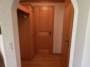 Un couloir étroit avec des portes en bois et un plancher en bois.