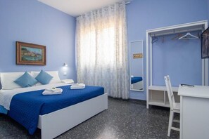 Quarto com cama, escrivaninha, cadeira, espelho e um quadro na parede.