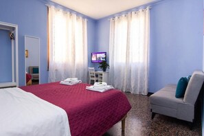 A hotel room with a bed, a chair, a TV, and curtains. - B&B CORSO ITALIA (Pisa)