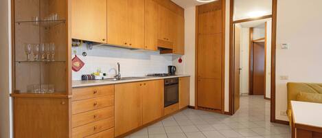 A modern kitchen with wooden cabinets, a stainless steel sink, and a built-in oven.
