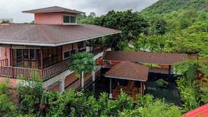 A multi-story building with balconies and a water feature in the foreground.