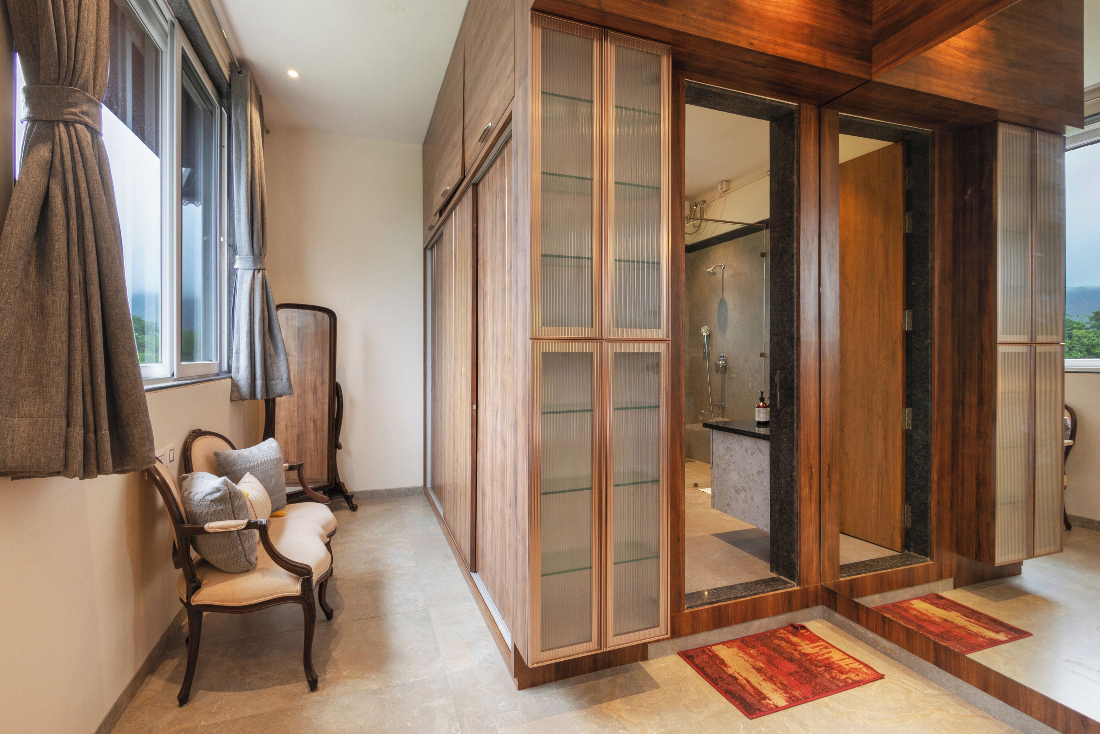 Une pièce avec un plancher en bois, une chaise, une grande porte coulissante et une vue sur l’extérieur.
