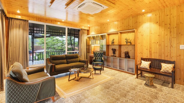 A cozy living room with a sofa, armchairs, a coffee table, and a fireplace.
