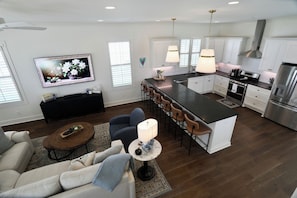 A modern kitchen with a central island, bar stools, and stainless steel appliances. - "The Blue Manor" by OVR (Oxford)