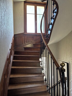 A wooden staircase with a curved handrail and a door at the top.