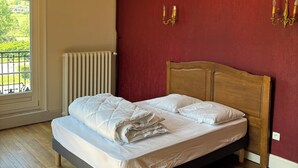 Un dormitorio con una cama de madera, un radiador y una pared roja.