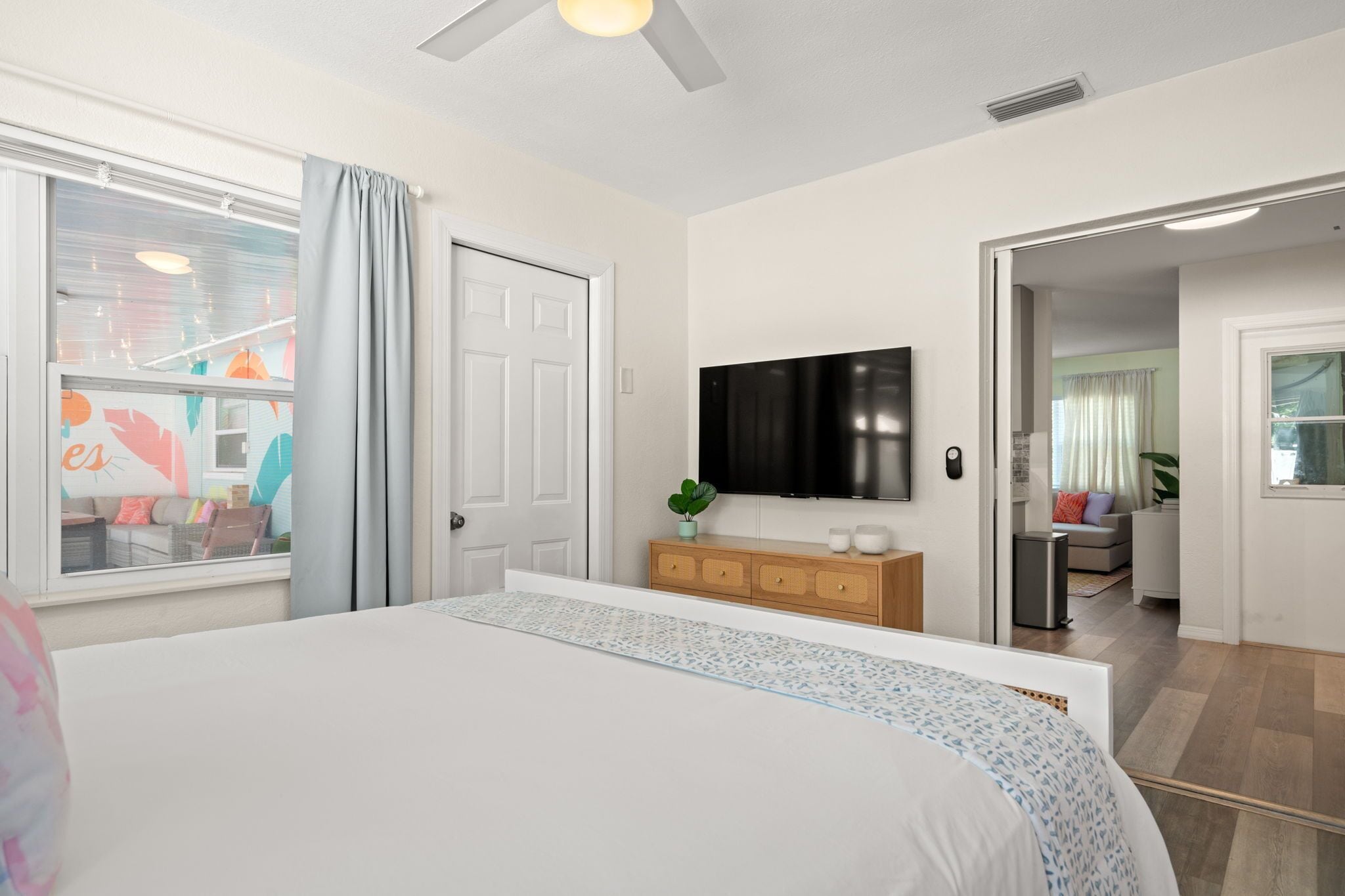 Une chambre d’hôtel avec un grand lit, un téléviseur à écran plat, une commode en bois et une vue sur l’extérieur.