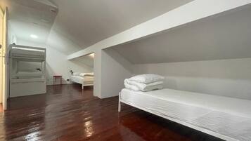 A room with a bunk bed, a small table, and a chair.