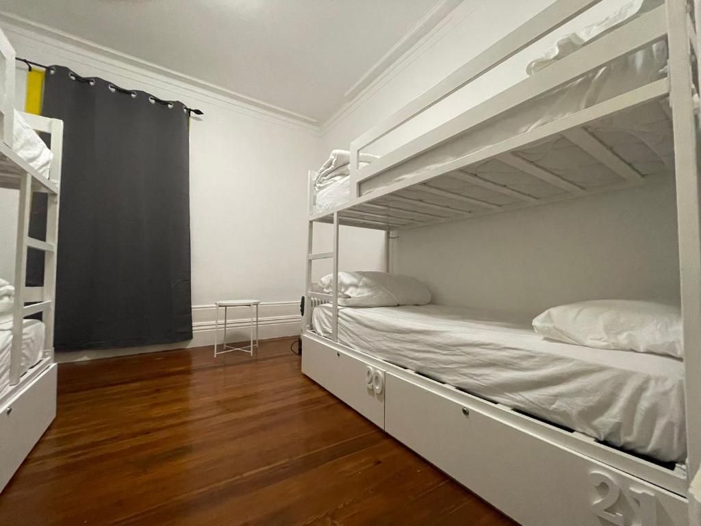 A bunk bed room with a small table and a curtain.
