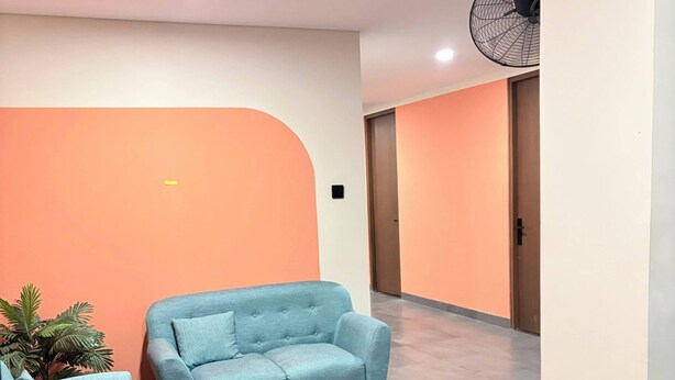 Uma área de estar moderna com um sofá, poltrona e mesa redonda.