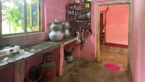 A kitchen with a gas stove, pots, and a shelf with utensils. - GaindaPhool Homestay, Chhichhli - Jashpur (Ganjenar)
