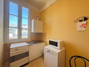 A compact kitchen with a stove, microwave, and sink. - Apartment 20m from the beach - 4 guests (Les Sables-d'Olonne)
