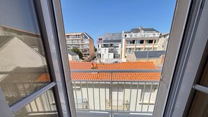 Un balcón con vistas a edificios vecinos y un tejado de tejas.