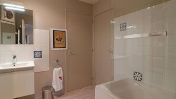 A modern bathroom with a bathtub, a sink, and a toilet.