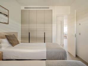 A bedroom with a bed, a wardrobe, and a door leading to another room. - Bright apartment in tranquil area - 4 guests (Fuengirola)