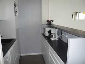 A compact kitchenette with a microwave, coffee maker, and a small refrigerator. - Apartment with AC and sea view - 4/5 guests (Port Camargue)