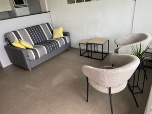 A modern living room with a grey sofa, two armchairs, a small coffee table, and a potted plant. - Apartment with AC and sea view - 4/5 guests (Port Camargue)