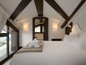 A bedroom with a large bed, a window, and a view of the mountains. - Duplex apartment in the center - 8 guests (Courchevel 1650)