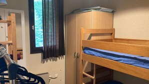 A bunk bed with a desk and a wardrobe in a room with a window. - Apartment 4 guests, slope view - Le Pleynet (Le Pleynet)