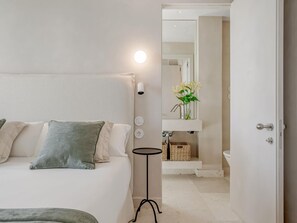 A bedroom with a bed, bedside table, and a bathroom visible through an open door. - Luxury villa with panoramic views - 10 guests (Málaga)